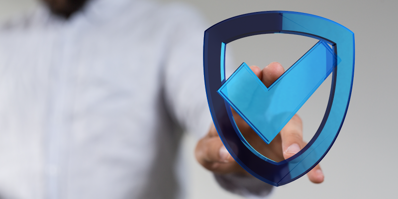 Man in background with fingers resting on protection shield symbol