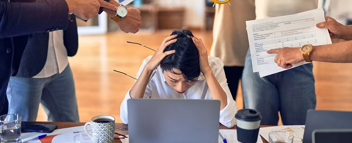 Man sitting at laptop with head in hands